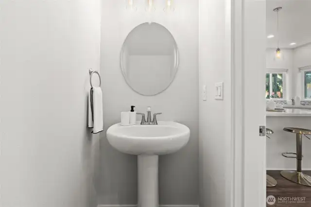 Sleek half bath with pedestal sink, conveniently located on main floor for guests.