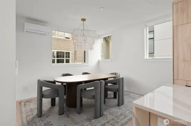 Above, the entry level sports a deluxe kitchen with expansive dining area. This image is virtually staged.