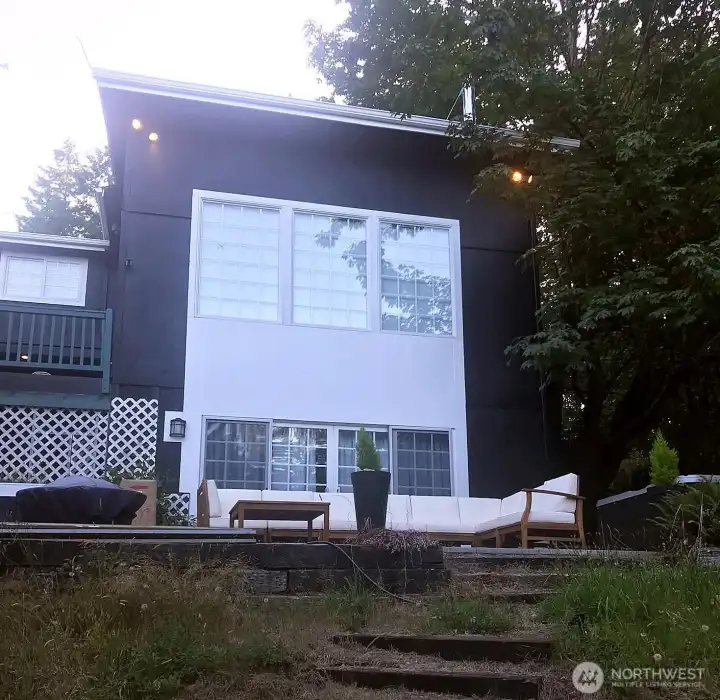 Floor-to-ceiling windows showcase sweeping views of the home’s expansive grounds.