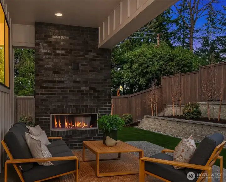Covered outdoor patio with fireplace; ideal for year-round enjoyment.