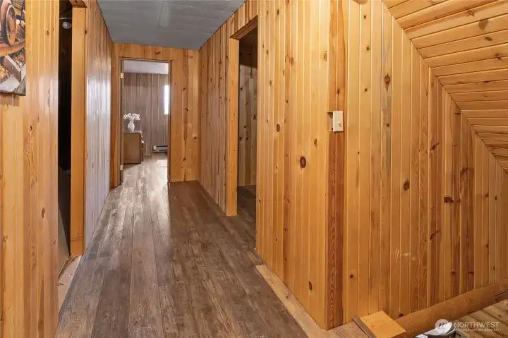 Hallway on upper level. There is storage space on the left, and a large closet/extra room on the right mid way down the hall.