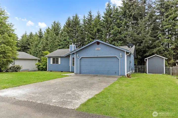 Large two car garage with parking pad and street parking out front, grass has been enhanced