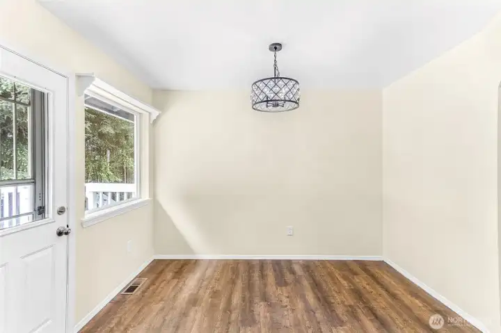 Spacious dining room with back door access to kitchen, deck, fenced back yard and storage sheds