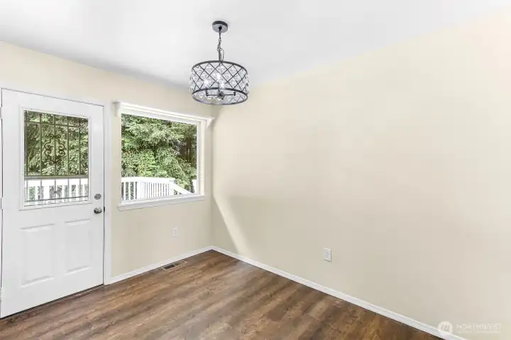 Spacious dining room with back door access to kitchen, deck, fenced back yard and storage sheds