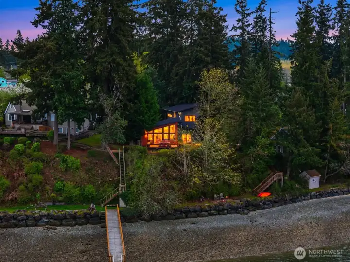 This architecturally striking Pacific Northwest home with a detached studio above the garage sits on a .41-acre lot with 110 feet of waterfront.