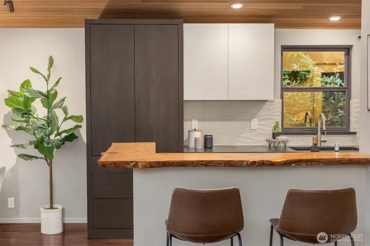 A handy eat-in kitchen bar with a live-edge countertop.