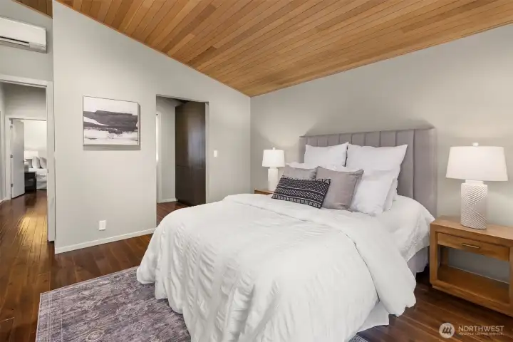 This bedroom has a connected bathroom and a walk-though closet with built-in modern wardrobes and drawers. Many thoughtful modern details in this home.