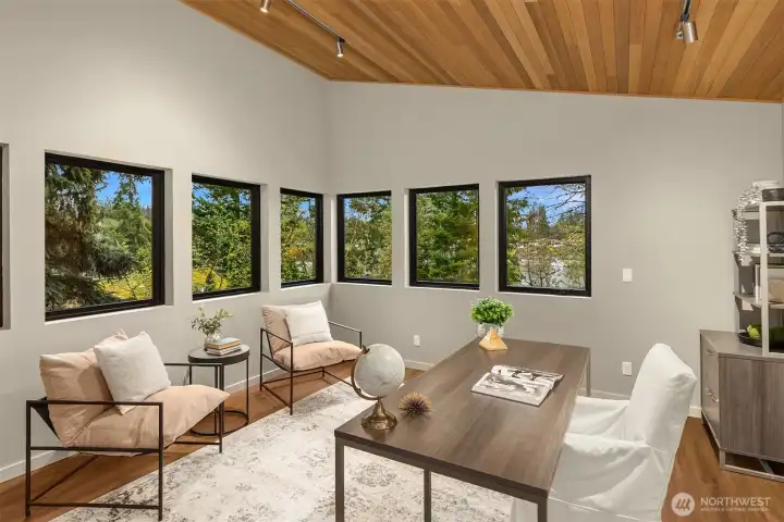 The Studio space has the same style and quality materials as the home. Vaulted wood ceilings, walls of windows and water views are all found in this fun space.