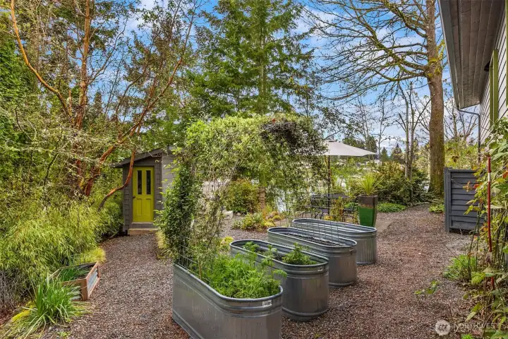 Back outside to the garden area on the property. Raised garden beds have irrigation. There is a  garden shed and a 2-person hot tub. The landscaping was intentionlly designed with low maintenance in mind.