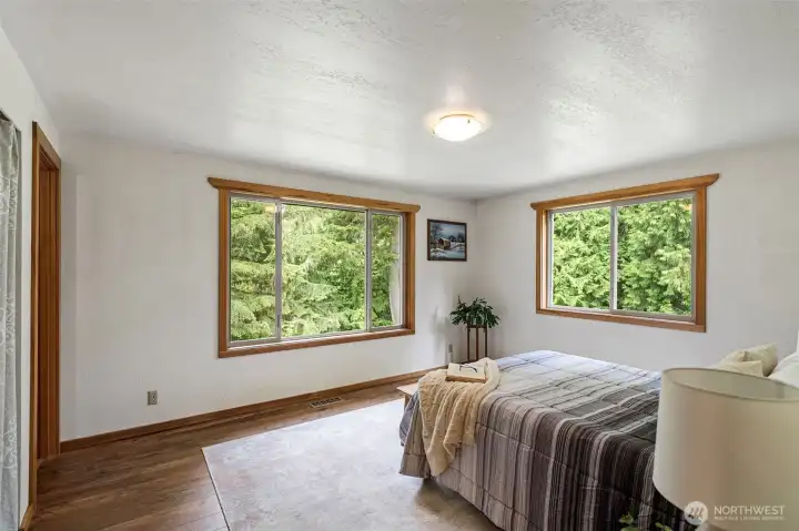 primary bedroom overlooks forest and pond