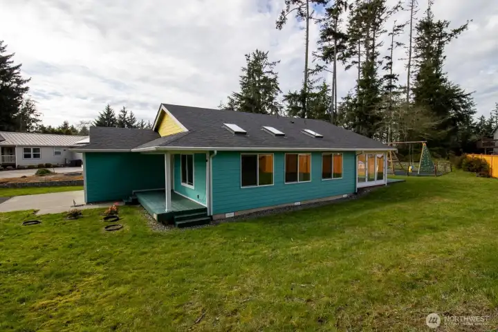 Single-story home on a spacious double lot with a large, level yard and play area, framed by mature evergreens. Single-story home on a spacious double lot with a large, level yard and play area, framed by mature evergreens.