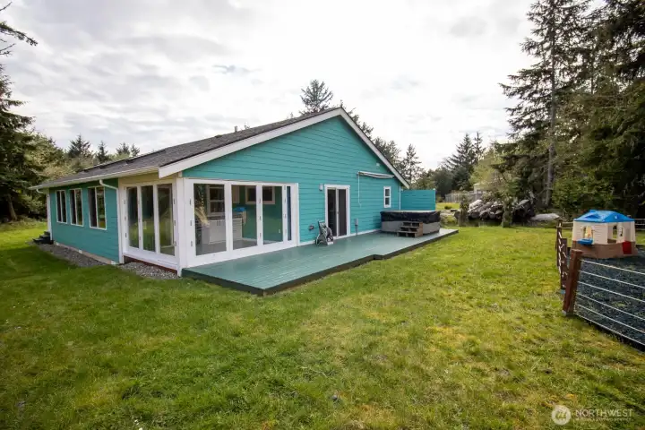 Window-wrapped sunroom opens to a spacious back deck with hot tub — a versatile entertainment space overlooking the private yard. Window-wrapped sunroom opens to a spacious back deck with hot tub — a versatile entertainment space overlooking the private yard.