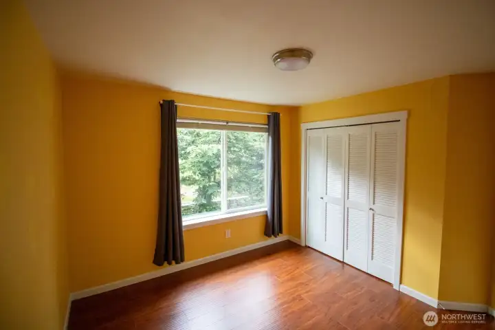 Bright second bedroom with rich hardwood floors, a double closet, and a large window overlooking the greenery. Bright second bedroom with rich hardwood floors, a double closet, and a large window overlooking the greenery.
