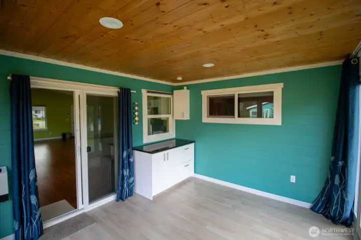 Bright, versatile sunroom with sliding-door flow to the living space, granite-topped storage, and a warm wood-paneled ceiling. Bright, versatile sunroom with sliding-door flow to the living space, granite-topped storage, and a warm wood-paneled ceiling.