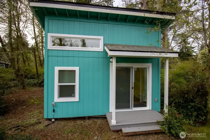Custom-built detached studio with a covered front porch and sliding-glass entry, tucked among the trees. Custom-built detached studio with a covered front porch and sliding-glass entry, tucked among the trees.