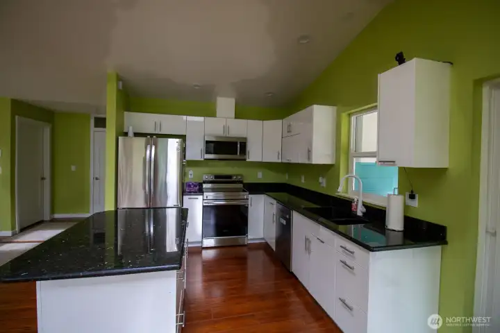 Spacious kitchen with a granite center island, stainless appliances, and generous cabinet storage Spacious kitchen with a granite center island, stainless appliances, and generous cabinet storage