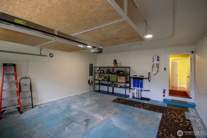 Attached garage with storage shelving and a whole-house water filtration system. Attached garage with storage shelving and a whole-house water filtration system.