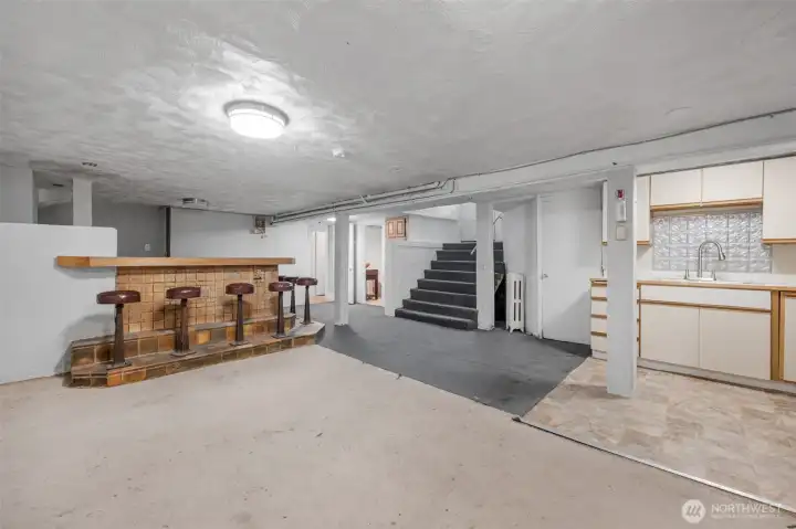 basement - view of bar and the first of 2 kitchenettes. Exterior door up the stairs opens to a fenced yard with a shed and garage's back door. basement - view of bar and the first of 2 kitchenettes. Exterior door up the stairs opens to a fenced yard with a shed and garage's back door.