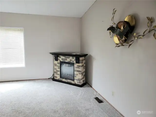View of the Living Room with Electric Fireplace and Newer Carpet.