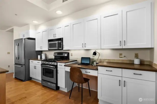 A built-in kitchen desk area is perfect for remote work, with ample surrounding counter space that can easily be converted into a full home office if needed.