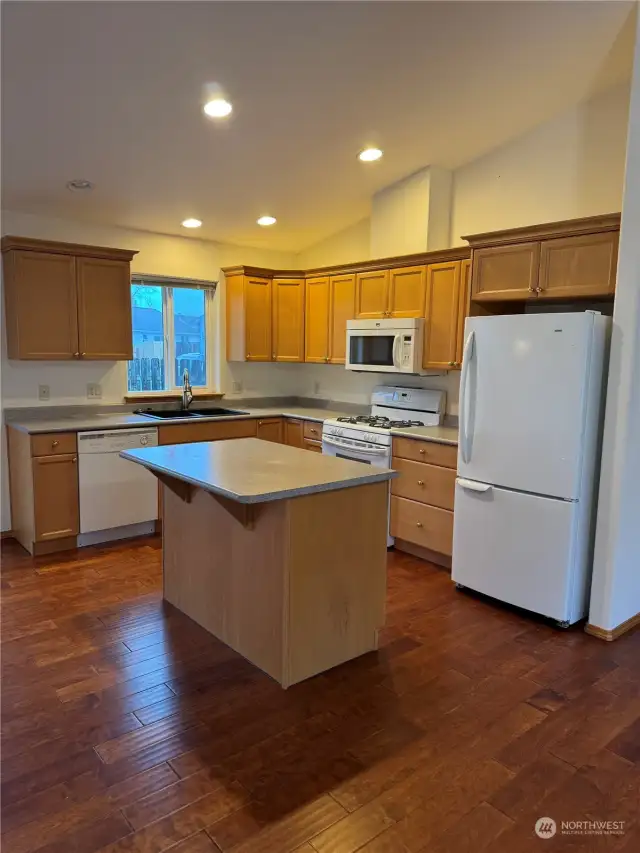 Kitchen island with eating bar and open to kitchen and dining area.