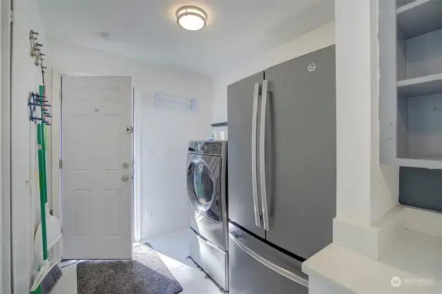 Utility room off of kitchen with door to side of the house.