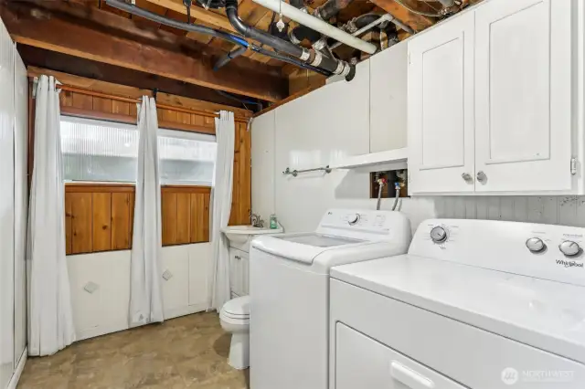 Brand new washer/dryer in utility room w/toilet and sink.