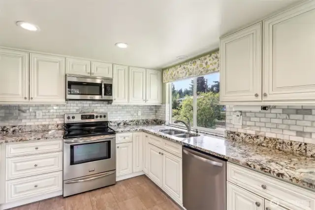 Granite counter tops w/stainless steel appliances in kitchen