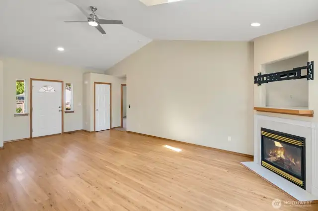 Vaulted ceilings and ceiling fan in living room with Cozy gas fireplace