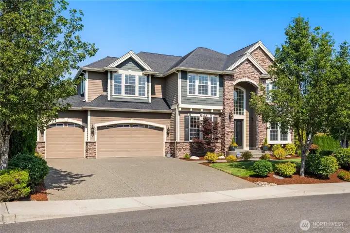 Expansive view of the home’s exterior highlighting the rare 6-car garage, wide driveway, and elegant curb appeal.