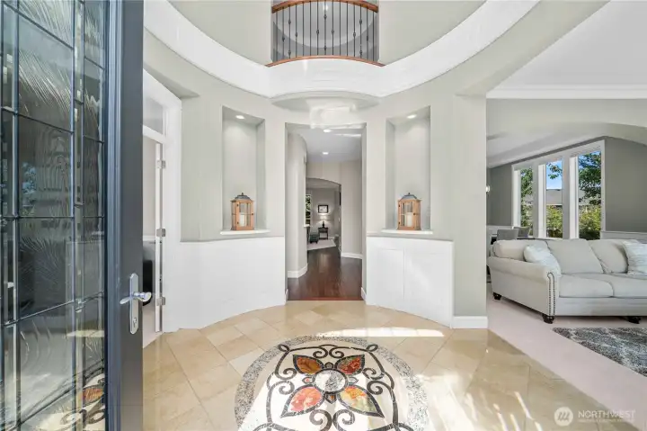 Dramatic two-story rotunda foyer with marble inlay, rounded walls, and extensive millwork sets the tone for timeless craftsmanship.