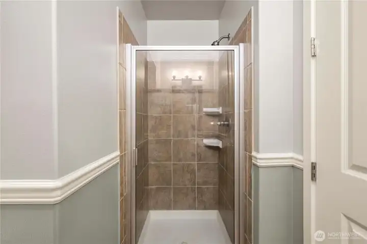 Convenient full walk-in shower with tile surround, adding versatility to the main-level bath.