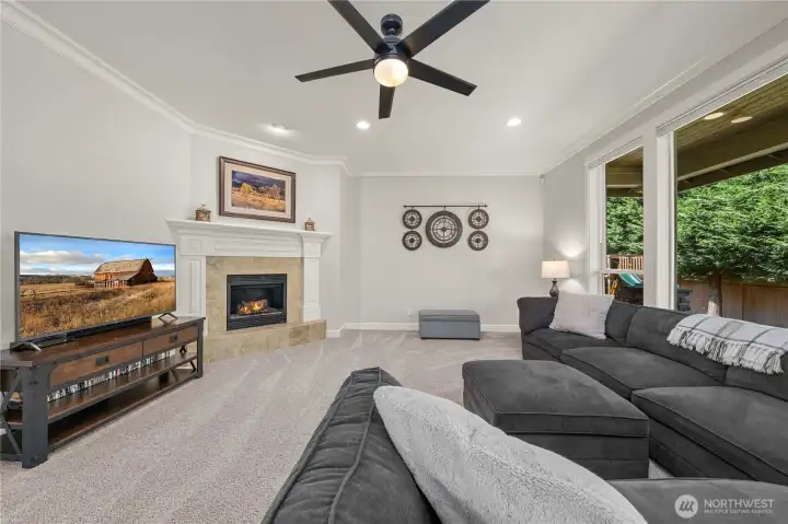 Spacious family room centered around a cozy fireplace, perfect for relaxing or entertaining.