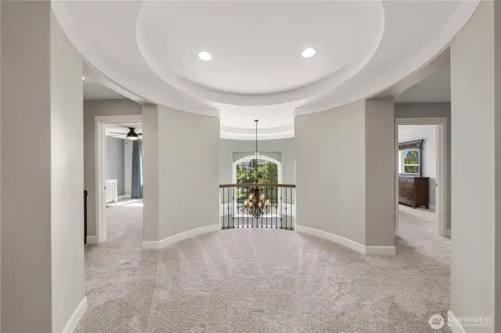 The upper rotunda landing offers a dramatic architectural focal point, with curved walls, recessed lighting, and views overlooking the grand foyer.