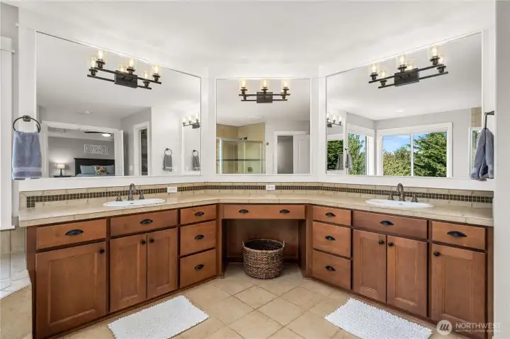 Expansive dual-sink vanity with abundant storage, elegant lighting, and oversized mirrors, perfect for a spa-like morning routine.