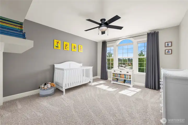 Bright and airy bedroom with a statement window, ceiling fan & neutral palette.