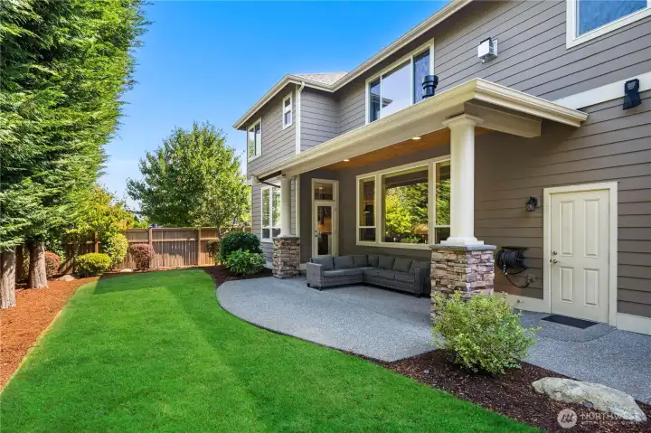 Relax year-round on the spacious covered patio with stone pillars, overlooking the private landscaped yard.