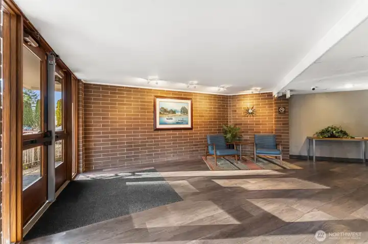 Welcoming building lobby with brick accents and comfortable seating.