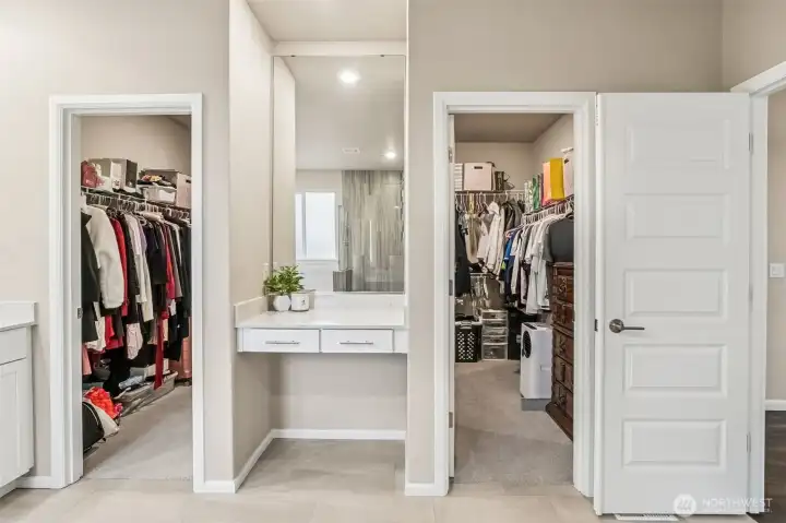 Wrap around walk in closet in primary with vanity station
