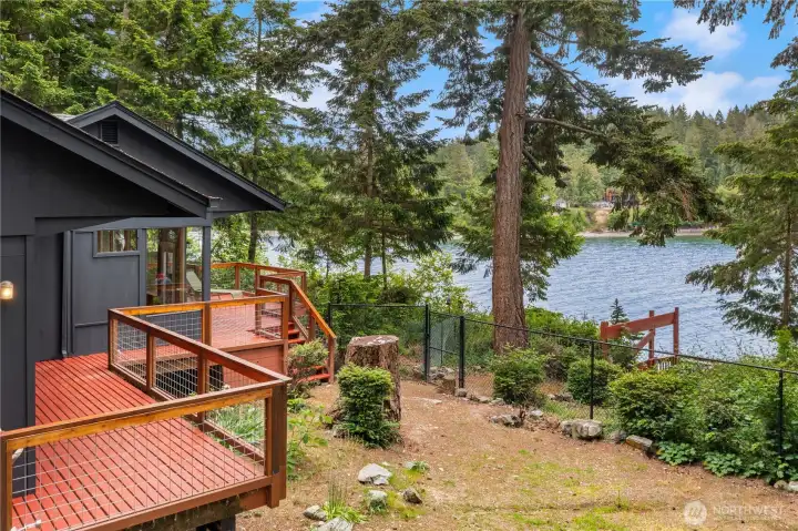 Property offers a fenced yard and stairway leading down to the water’s edge.