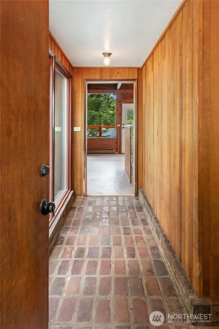 Enter into main house on rustic brick flooring.