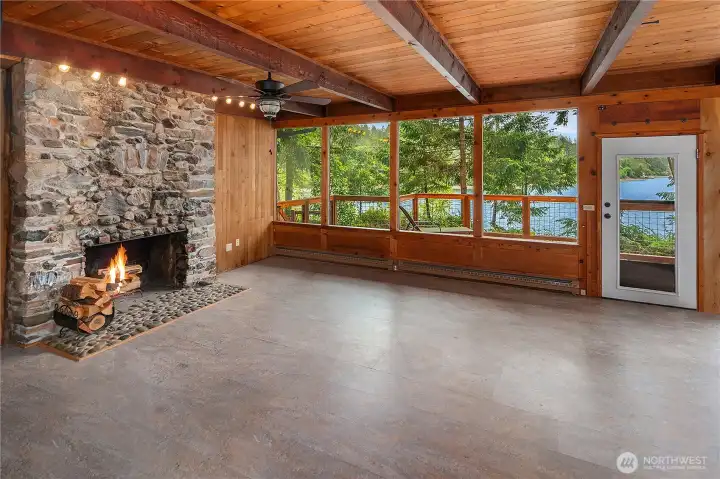 Gather in the spectacular living room where a wall of windows captures unbeatable views, while exposed beams and a stunning rock fireplace create warmth and character.