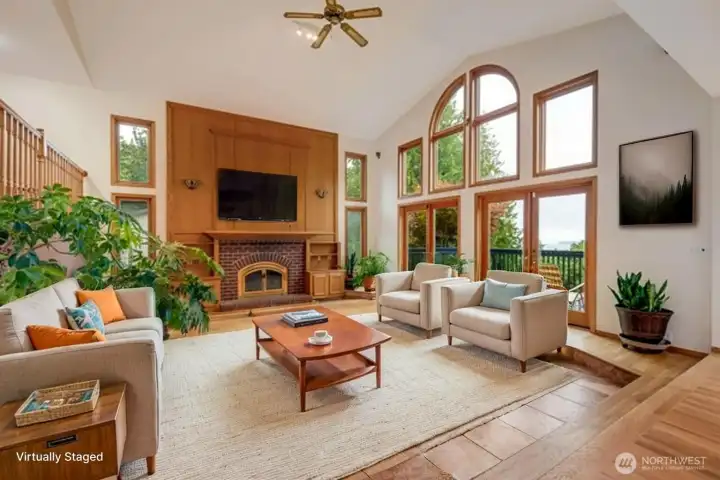 Great room with soaring ceilings and floor to ceiling windows and French doors to the large deck and gorgeous view, beautiful wood detail surrounding the grand fireplace. Great room with soaring ceilings and floor to ceiling windows and French doors to the large deck and gorgeous view, beautiful wood detail surrounding the grand fireplace.
