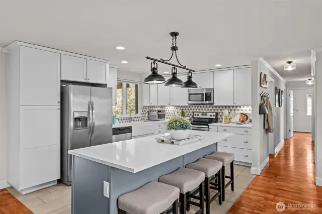Chic, updated kitchen with soft closing cabinets, penny tile backsplash, and island seating.