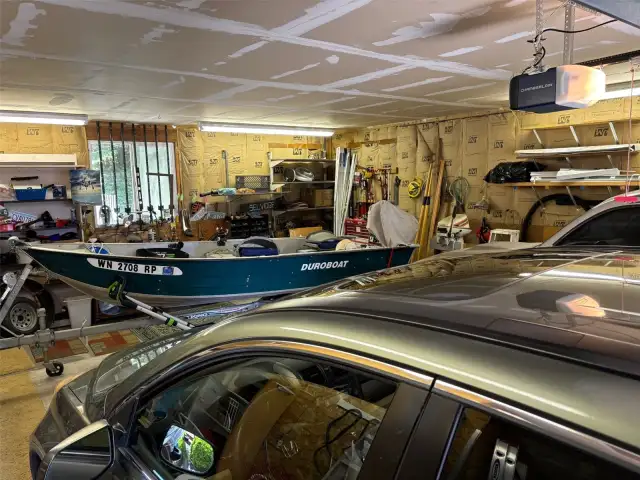 Garage with 2 cars and a boat.