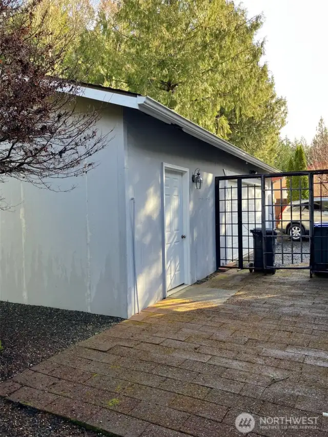 Shop/2 car garage with pavers and ornamental fence.