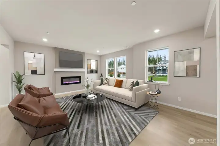 Family room with cozy fireplace with lots of windows to let natural light in.  Actual home is under construction and materials, colors, and finishes will vary. See site agent for details.