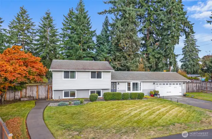 CURB APPEAL | This home is framed by traditional PNW evergreens, ornamental trees and shrubs that provide sun and wind protection.