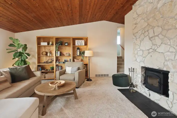 The living room with wood burning fireplace insert  (recently serviced) and lovely wood vaulted ceiling.