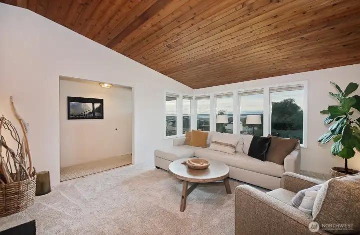 Enjoy the westerly water and mountain views from the living room.  To the left of the windows is the entry hall leading into